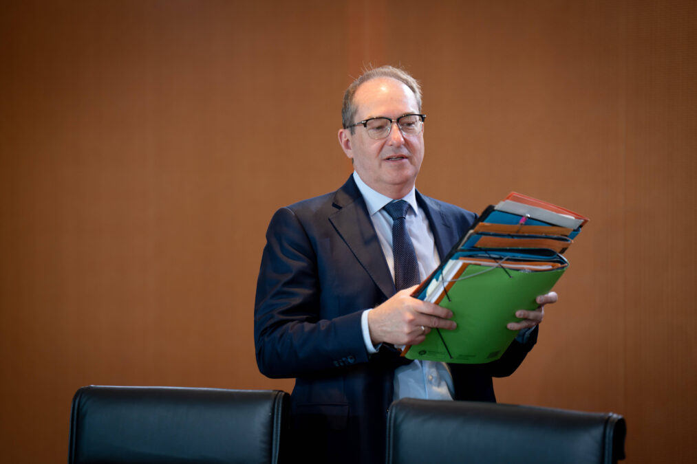 Mann im Anzug mit Stapel Akten in der Hand