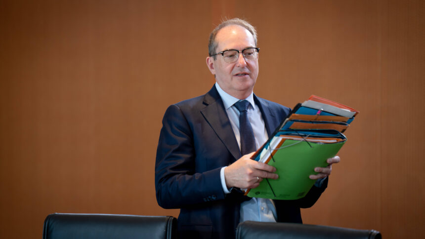 Mann im Anzug mit Stapel Akten in der Hand