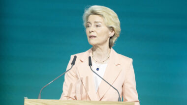 Ursula von der Leyen mit hellem Blazer steht an einem Rednerpult