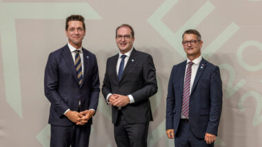 Drei Männer in Anzug.