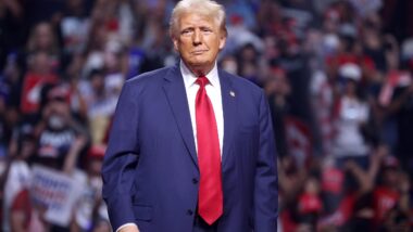 Der US-Präsident in blauem Anzug mit roter Krawatte vor einem großen Publikum