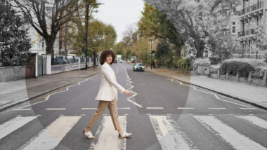 Frau in weißem Blazer überquert Zebrastreifen in der Abbey Road in London.