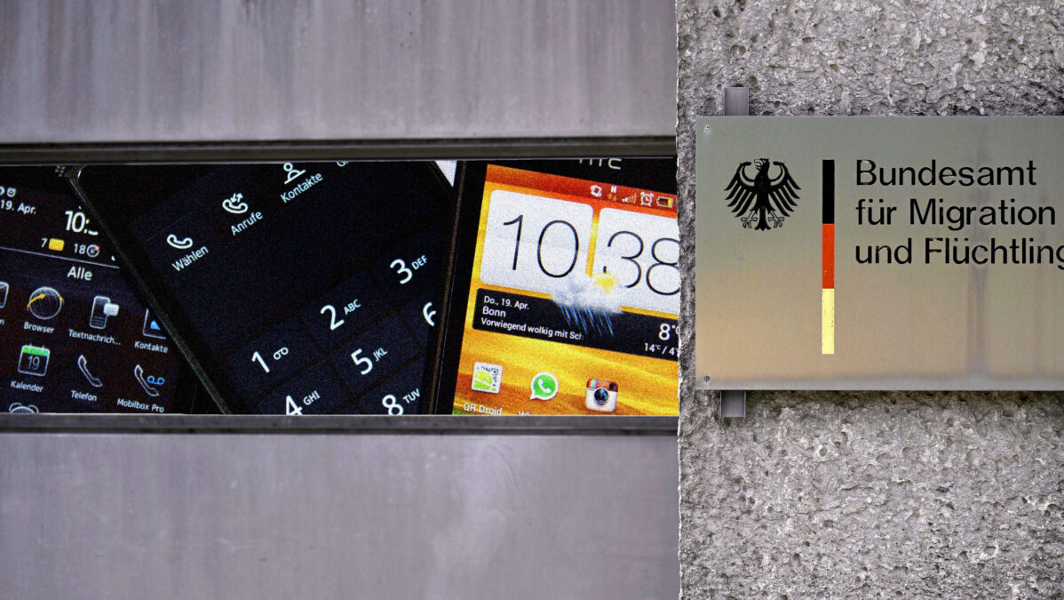 Bamf-Gebäude-Eingang, in einem Fenster sind Handys zu sehen.