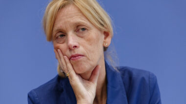 Karin Prien stützt Gesicht in Hand und schaut kritisch