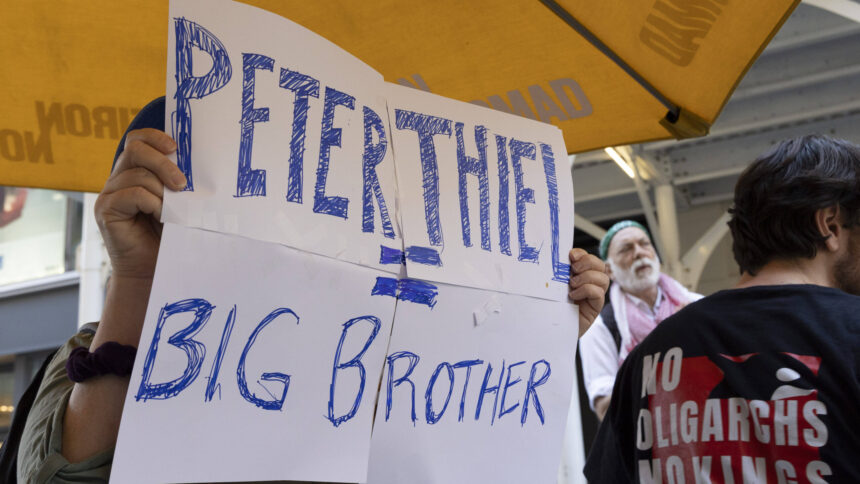 Mensch hält Plakat mit der Aufschrift "Peter Thiel = Big Brother"