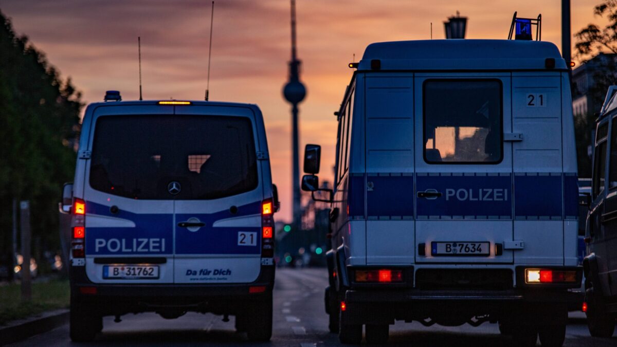 Zwei Polizeifahrzeuge, Sonnenuntergang, im Hintergrund der Fernsehturm.