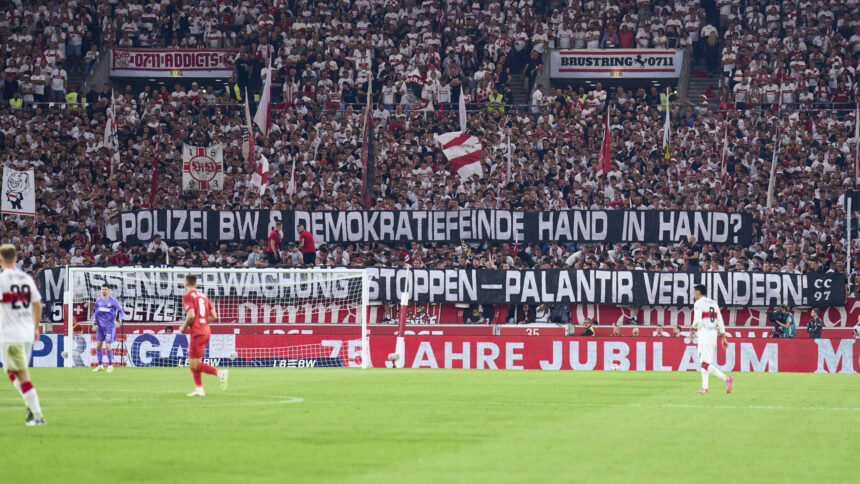 Fußballfans halten Transparent "Polizei BW & Demokratiefeinde Hand in Hand. Massenüberwachung stoppen - Palantir verhindern."
