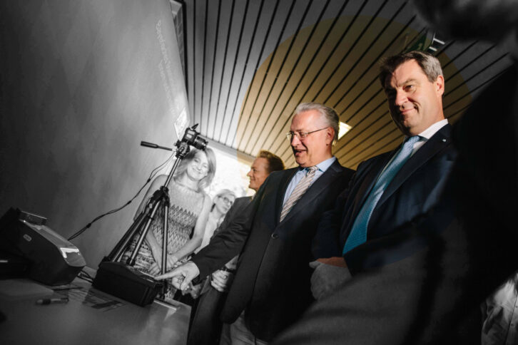 Zwei Männer im dunklen Anzug schauen auf technische Geräte.