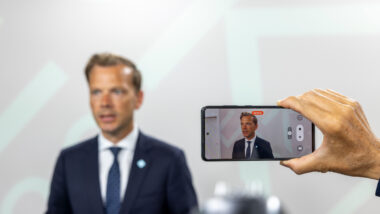 Mann vor Leinwand, Smartphone nimmt ihn auf.