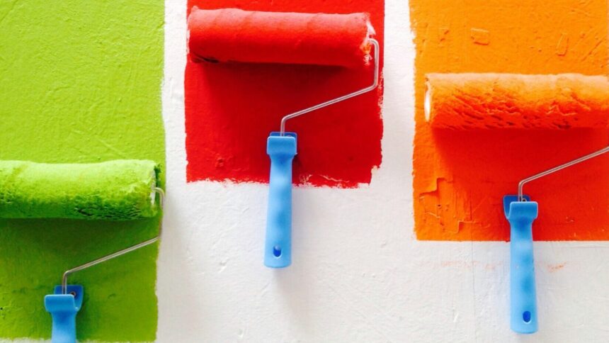 Bunte Farbrollen malen an einer Wand