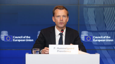 Mann mit Krawatte vor blauer Wand, Pressekonferenz