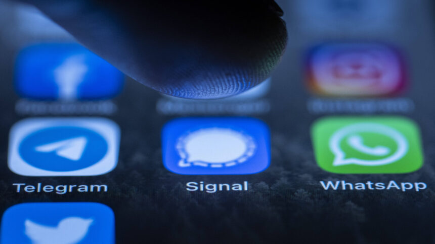 Smartphone-Bildschirm mit Messenger-Icons und Daumen, der drückt