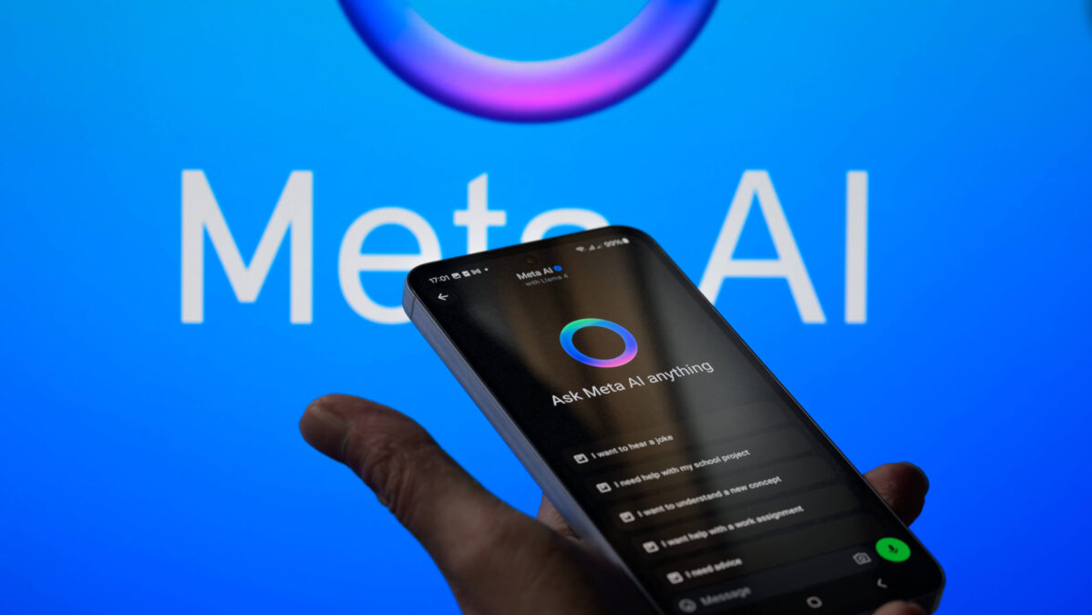 Eine Hand hält ein Handy, auf dem der Meta Chatbot aktiv ist, vor ein Meta AI Logo