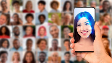 Ein Smartphone mit einem identifizierten Gesicht, dahinter verschwommene weitere Gesichter.