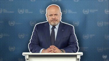 Karim Khan am Rednerpult vor verpixeltem Hintergrund