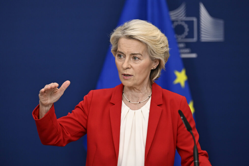 EU-Kommissionspräsidentin Ursula von der Leyen bei einer Rede im roten Sakko vor EU-blauem Hintergrund.