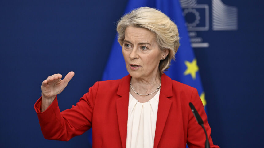 EU-Kommissionspräsidentin Ursula von der Leyen bei einer Rede im roten Sakko vor EU-blauem Hintergrund.