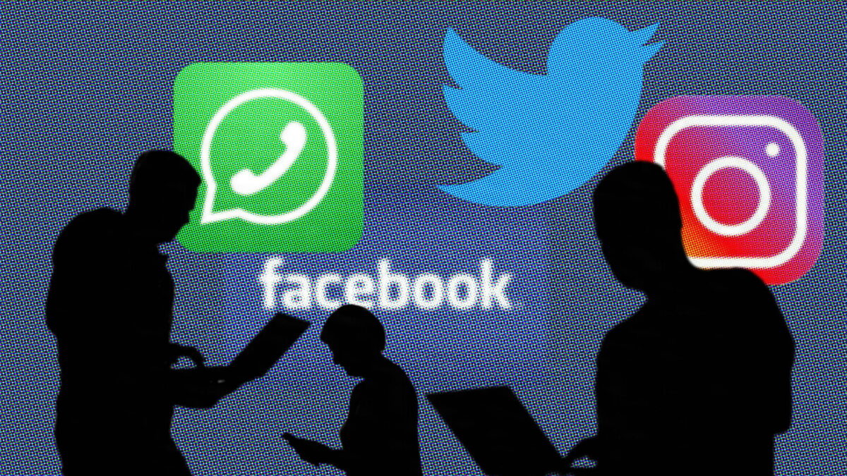 Menschliche Silhouetten mit Laptops in den Händen, dahinter die Logos sozialer Netzwerke.