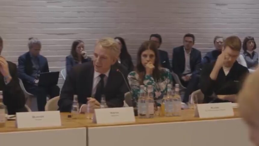 Bild eines Konferenztisches mit Personen.