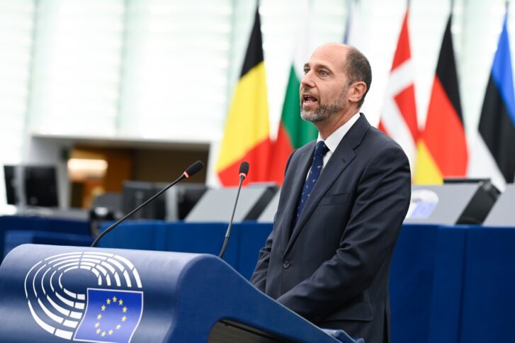 Navarrete an einem Rednerpult, im Hintergrund Flaggen von EU-Ländern