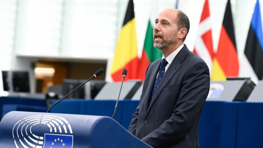 Navarrete an einem Rednerpult, im Hintergrund Flaggen von EU-Ländern