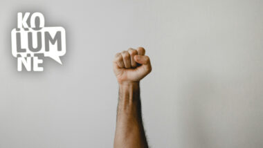 Eine Faust vor einer weißen Wand.