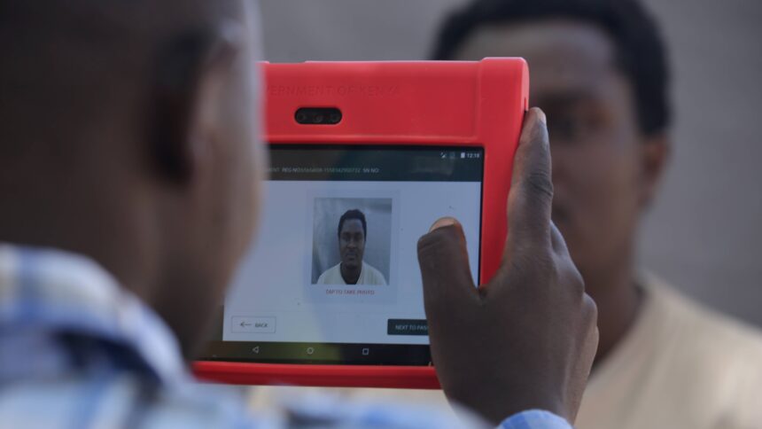 Eine Person hält eine Art Tablet und fertigt damit ein Passfoto einer anderen Person an