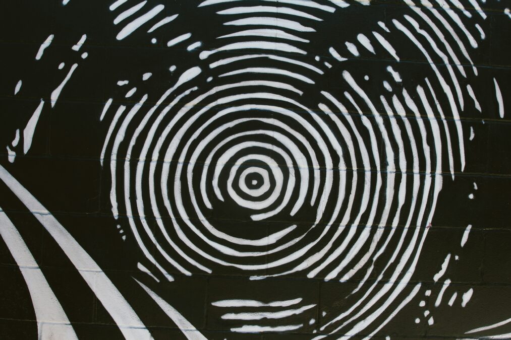 Ein schwarz-weiß Bild, das ein Gesicht zeigt, das wie ein Fingerabdruck gemalt ist.