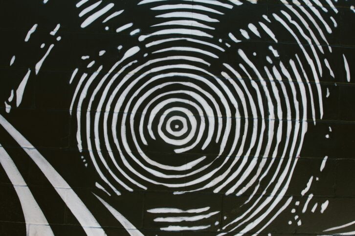 Ein schwarz-weiß Bild, das ein Gesicht zeigt, das wie ein Fingerabdruck gemalt ist.