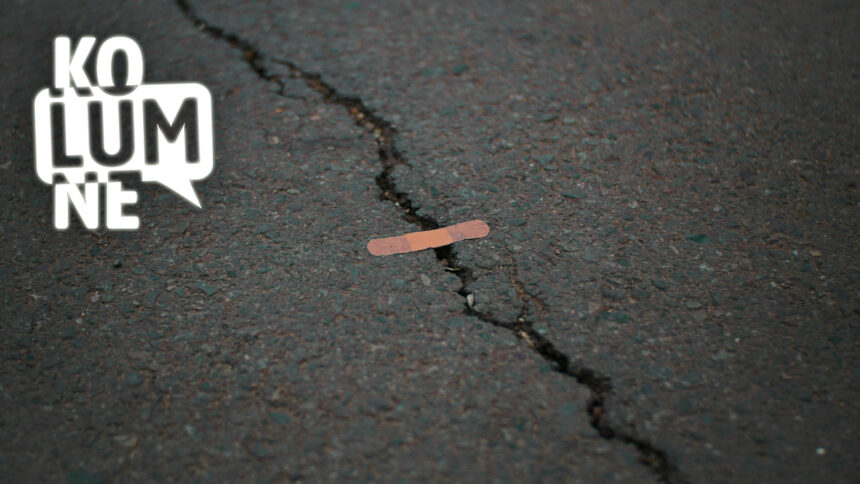 Ein Pflaster klebt auf einem Riss im Asphalt