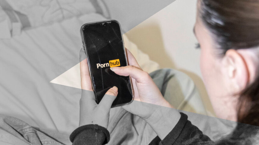 Eien Person hat ein Smartphone in der Hand, auf dem das Logo von Pornhub zu sehen ist.