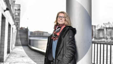 Die Berliner Datenschutzbeauftragte Meike Kamp steht vor einer Säule an der Spree in Berlin.