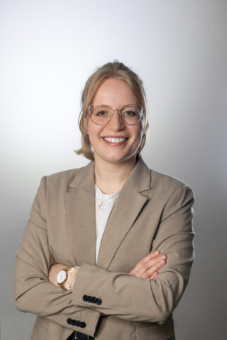 Blonde Person mit Brille und gekreuzten Armen