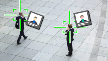 Zwei Business-Männer telefonieren auf einem öffentlichen Platz. Grüne Fadenkreuze haben sie ins Visier genommen. Daneben sind digitale Steckbriefe zu sehen.