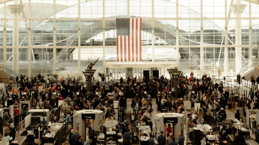 Flughafenhalle in Denver, im Hintergrund eine große US-Flagge