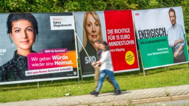 Wahlplakate von Sahra Wagenknecht, BSW, Petra Köpping, SPD, und von Ministerpräsident Michael Kretschmer, CDU, auf einer grünen Wiese,
