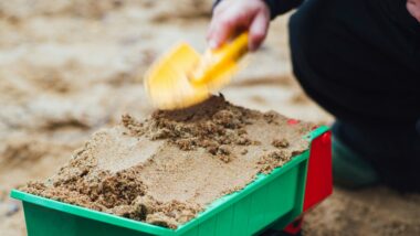 Eine Spielzeuglader und eine gelbe Schaufel mit Sand
