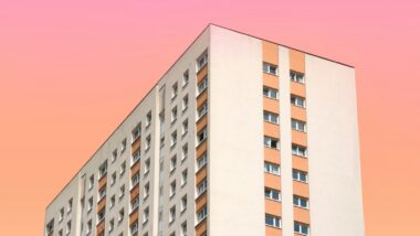 Ein großes Wohnhaus vor einem farbigen Himmel