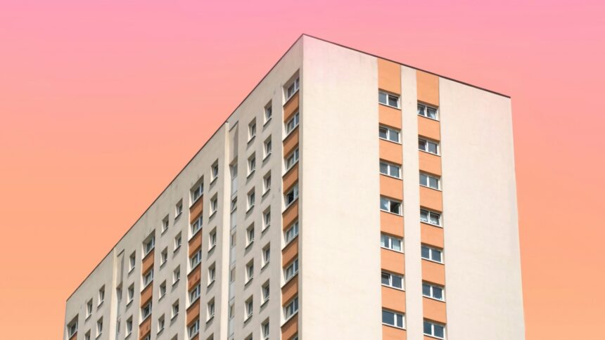 Ein großes Wohnhaus vor einem farbigen Himmel