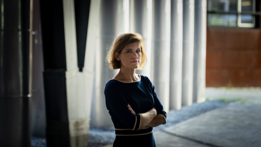 Mensch steht mit gekreuzten Armen vor einer Wand