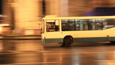 Bild eines weißen Busses, durch den verschwommenen Hintergrund sieht es so aus, als würde er schnell fahren