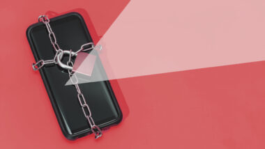 Ein Smartphone, umwickelt mit eiserner Kette und Vorhänge-Schloss.