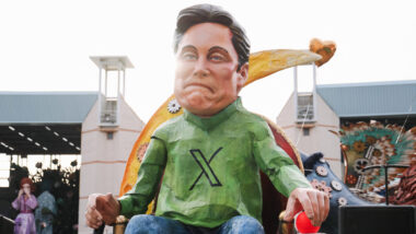 Eine Karikaturfigur von Elon Musk mit einem grünen Hemd mit dem X-Logo darauf, die auf einem Thron sitzt.