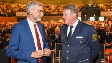 Zwei alte Männer schauen sich in die Augen und lächeln.