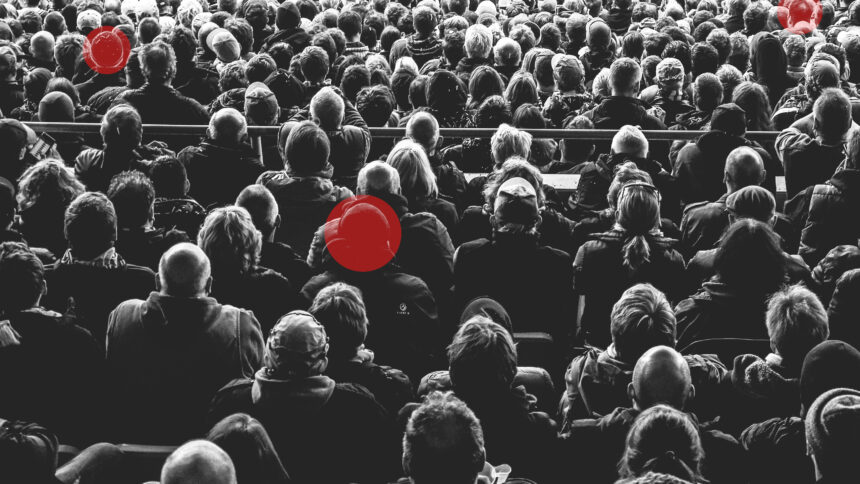 Menschenmenge von hinten fotografiert, drei Personen sind mit einem roten Kreis markiert.