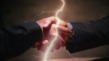 Händeschütteln, darüber ein Blitz
