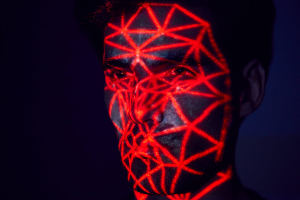 Mensch mit rotem Raster, das auf das Gesicht projiziert ist