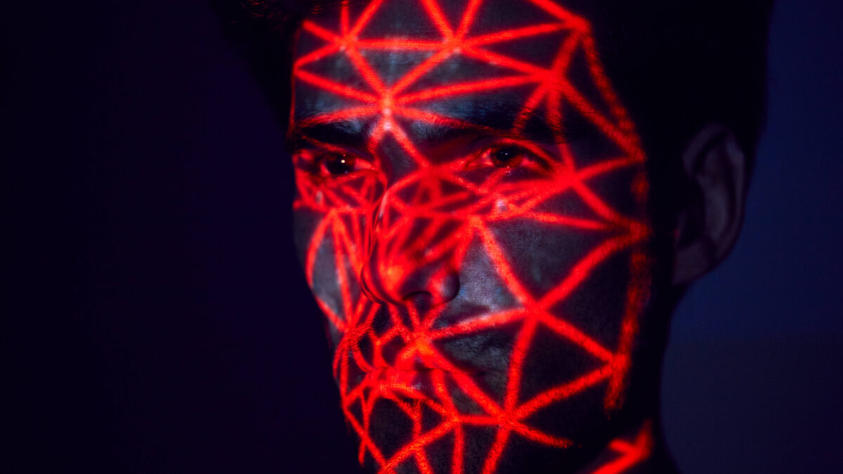 Mensch mit rotem Raster, das auf das Gesicht projiziert ist