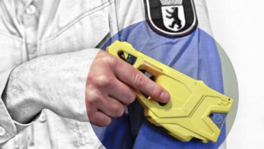 Ein Polizist hält einen Taser.