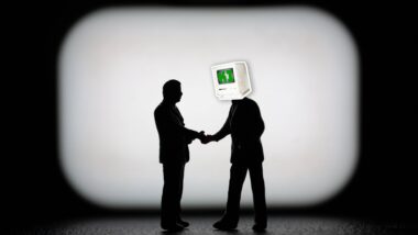 Schattenrisse von zwei Figuren, die Herren mit Jacket darstellen; der eine von beiden trägt statt eines Kopfes einen Computerbildschirm mit der Aufschrift "KI"